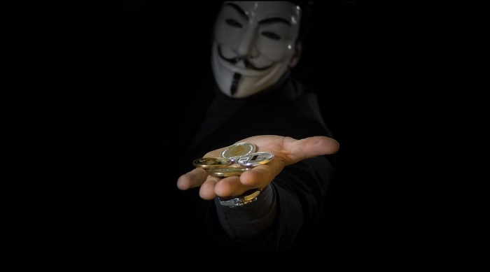 Hacker holding handful of BItcoin