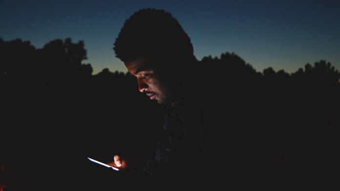 A Man Holding Smartphone at Night
