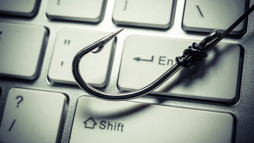 Fishing hook on top of a keyboard to depict phishing