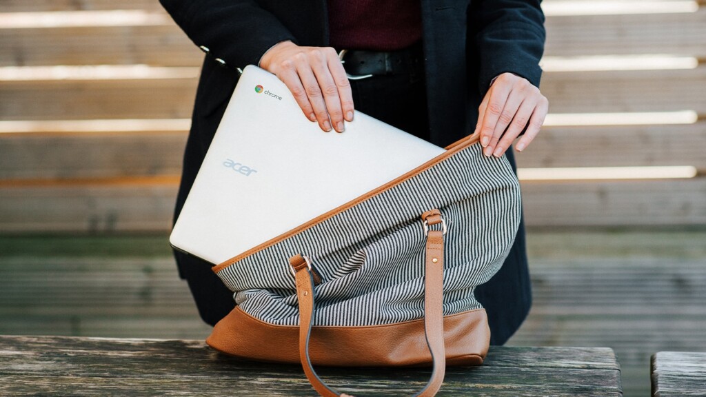 Image of a woman putting a Chromebook in a bag
